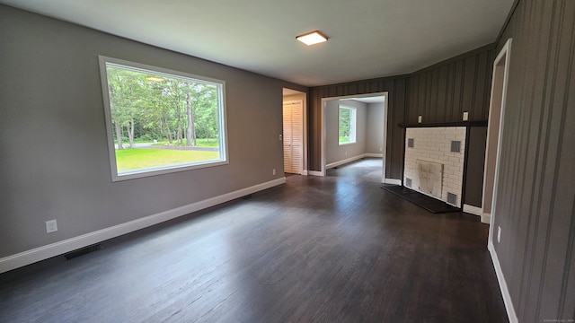 unfurnished living room featuring a fireplace and dark hardwood / wood-style flooring