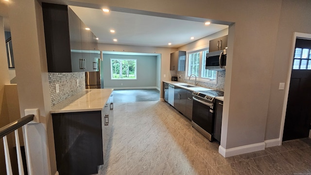 kitchen featuring backsplash, stainless steel appliances, and plenty of natural light