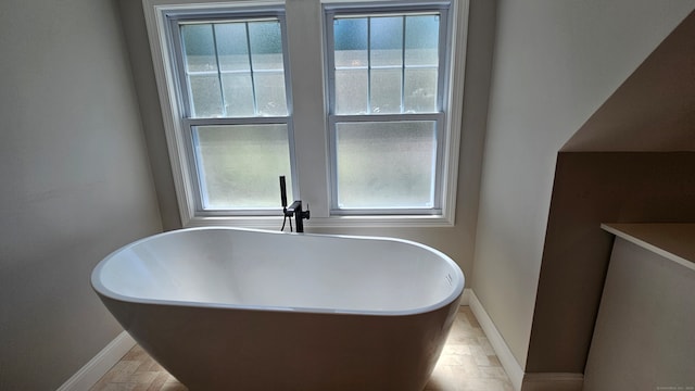 bathroom with a washtub and a healthy amount of sunlight