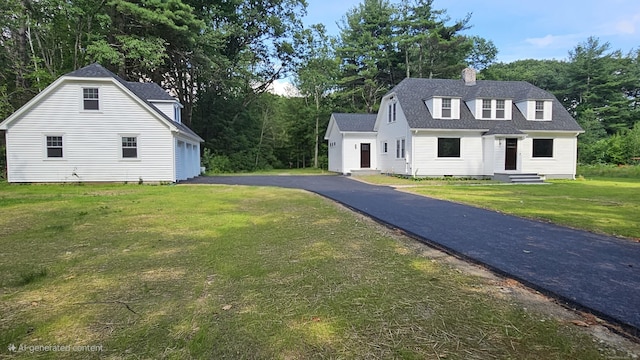 107 N Hollow Rd, Hartland, CT 06027 - view of front of property featuring a chimney, roof with shingles, a front lawn, a garage, and asphalt driveway