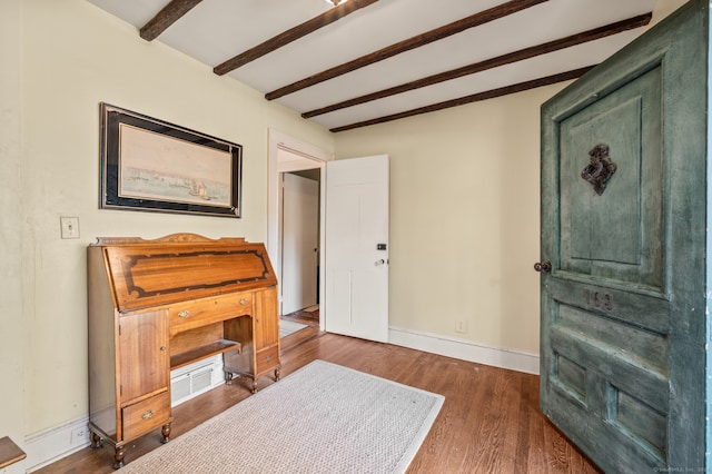 misc room featuring beam ceiling and dark wood-type flooring