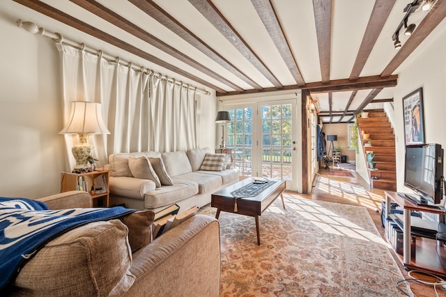 living room featuring beamed ceiling and light hardwood / wood-style flooring