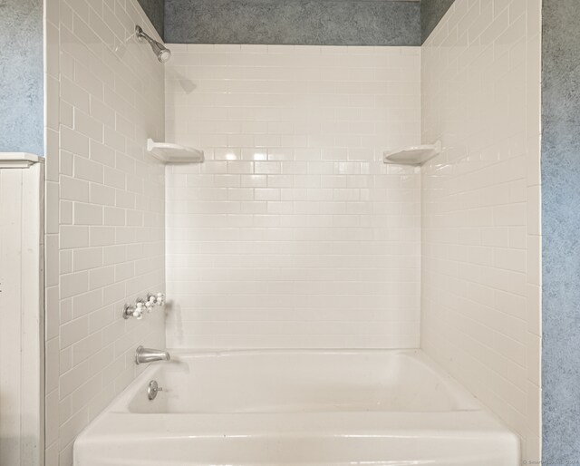 bathroom featuring tiled shower / bath