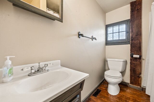 bathroom with hardwood / wood-style floors, vanity, and toilet