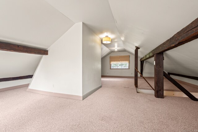 additional living space with light colored carpet and vaulted ceiling