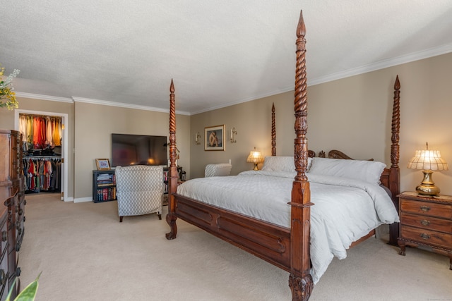 bedroom featuring light colored carpet, a textured ceiling, a walk in closet, a closet, and ornamental molding