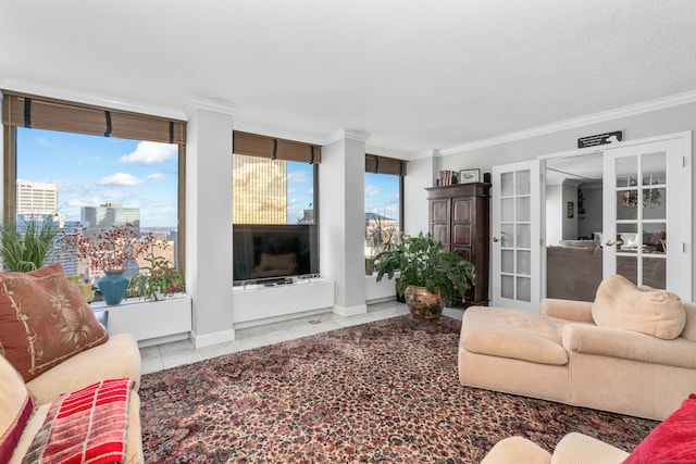 living room featuring a textured ceiling, tile patterned floors, plenty of natural light, and ornamental molding