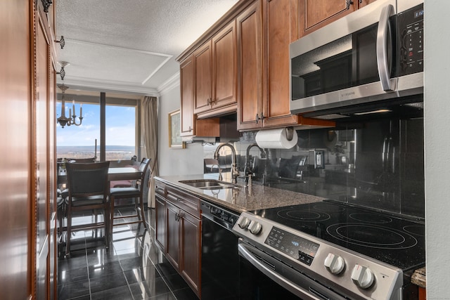 kitchen featuring sink, dark stone countertops, a textured ceiling, decorative backsplash, and appliances with stainless steel finishes