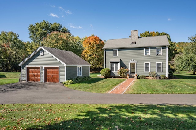 colonial house with an outbuilding, a front yard, and a garage