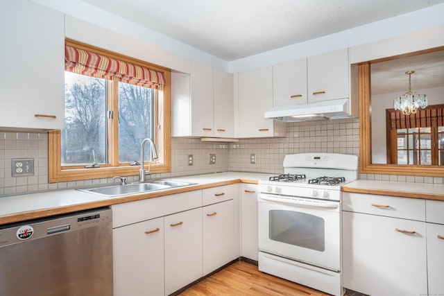 kitchen featuring white range with gas stovetop, pendant lighting, white cabinetry, and dishwasher