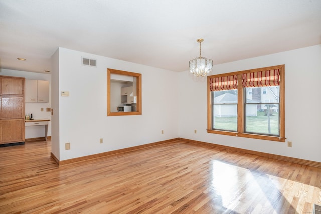 interior space with light hardwood / wood-style flooring and an inviting chandelier