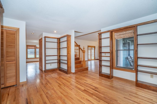 empty room with light hardwood / wood-style floors and a textured ceiling