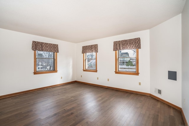 empty room featuring dark hardwood / wood-style flooring and a textured ceiling