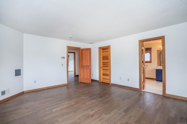 empty room featuring dark hardwood / wood-style floors and a textured ceiling