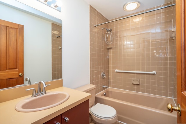 full bathroom featuring tiled shower / bath combo, toilet, and vanity