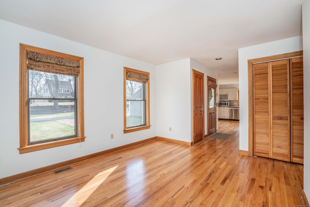 unfurnished room featuring light hardwood / wood-style floors and a wealth of natural light