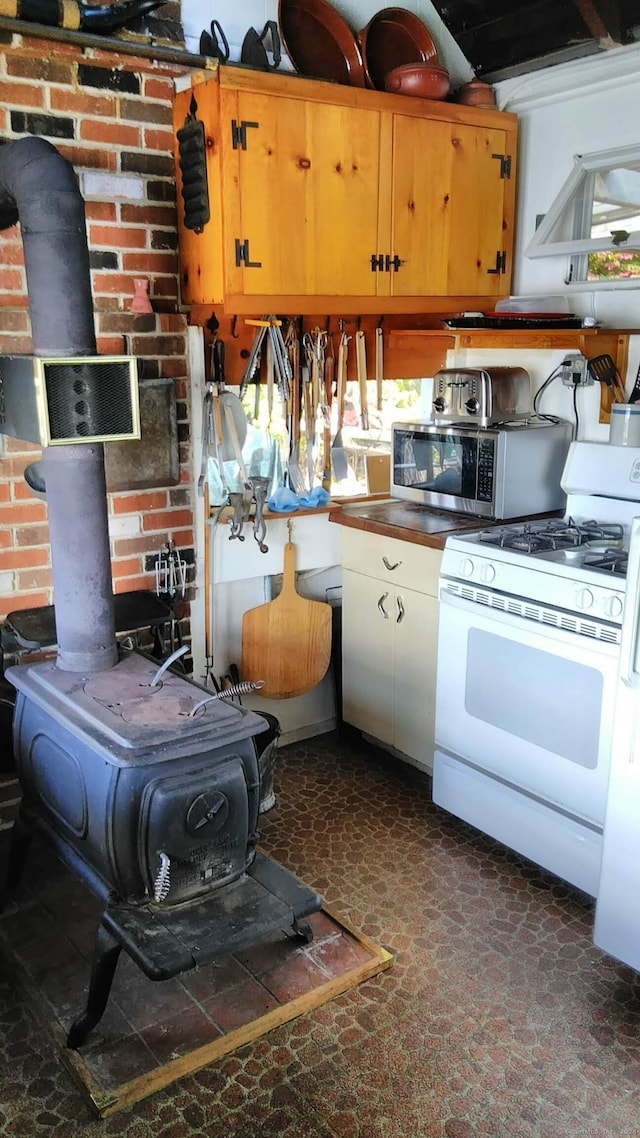 kitchen featuring gas range gas stove and a wood stove