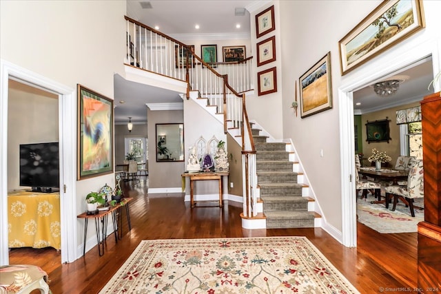 foyer with crown molding, dark wood-type flooring, and a healthy amount of sunlight