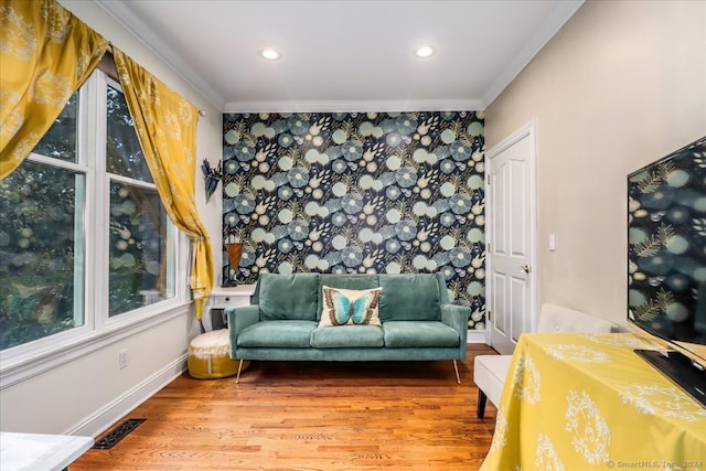 living area with hardwood / wood-style flooring and crown molding