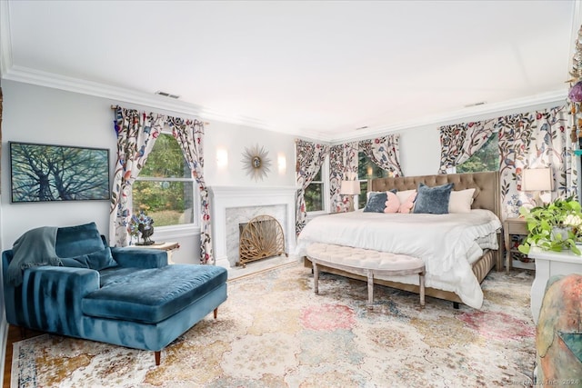 bedroom featuring crown molding, a high end fireplace, and hardwood / wood-style floors