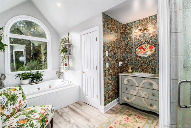 bathroom featuring vanity, hardwood / wood-style flooring, vaulted ceiling, and separate shower and tub