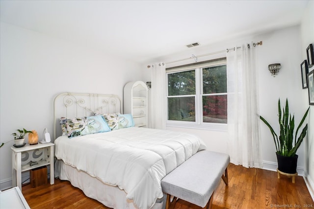 bedroom with dark hardwood / wood-style floors