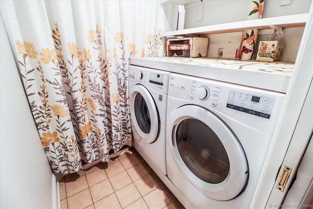 laundry area featuring washing machine and clothes dryer and light tile patterned floors