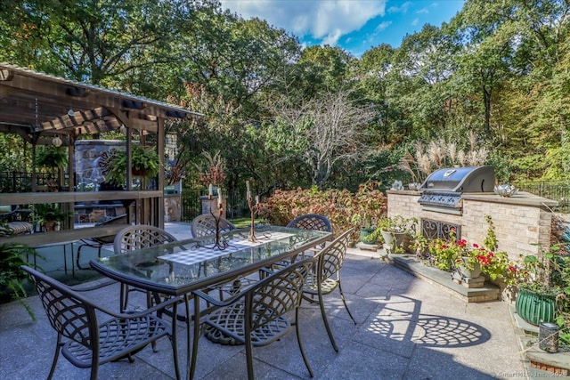 view of patio with area for grilling and a pergola