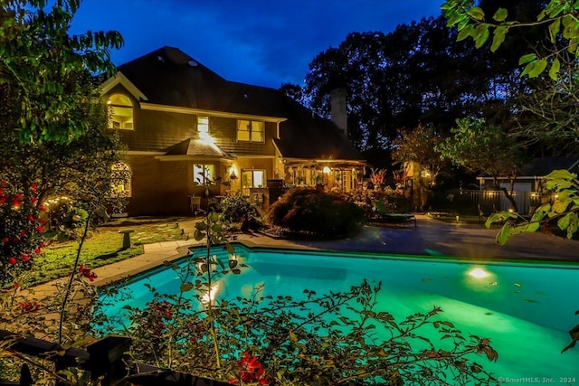 pool at twilight featuring a patio area