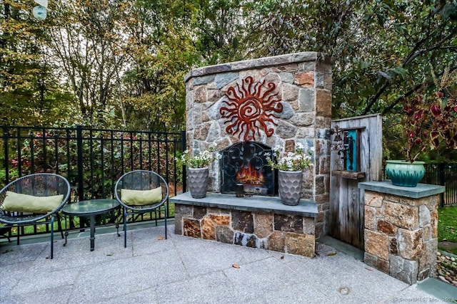 view of patio featuring an outdoor stone fireplace