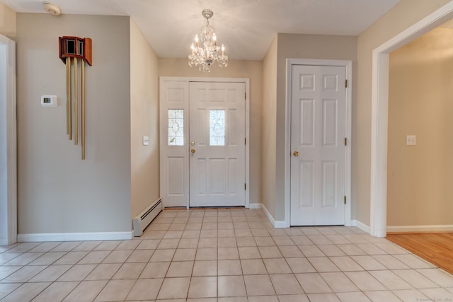 foyer entrance with a notable chandelier, a textured ceiling, baseboard heating, and light tile patterned floors