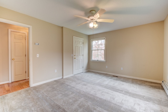 unfurnished bedroom featuring a baseboard radiator, light colored carpet, and ceiling fan