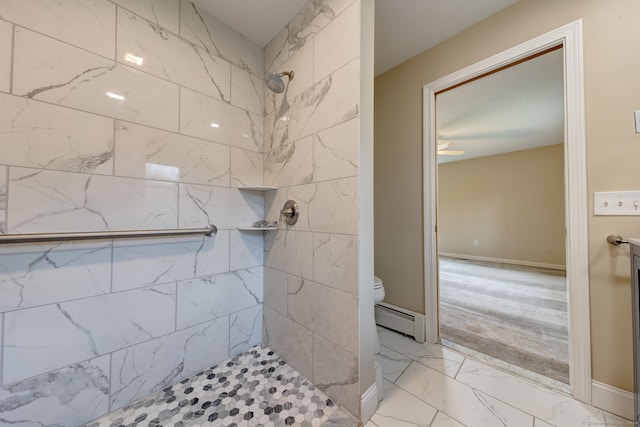 bathroom featuring a tile shower, a baseboard heating unit, and toilet