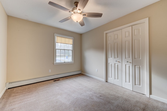 unfurnished bedroom with a closet, ceiling fan, a baseboard heating unit, and light colored carpet