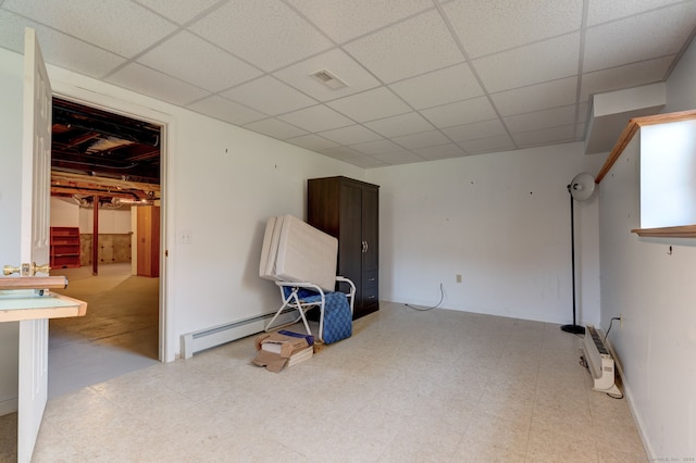 interior space featuring a paneled ceiling and baseboard heating