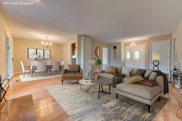 living room with a chandelier and light wood-type flooring