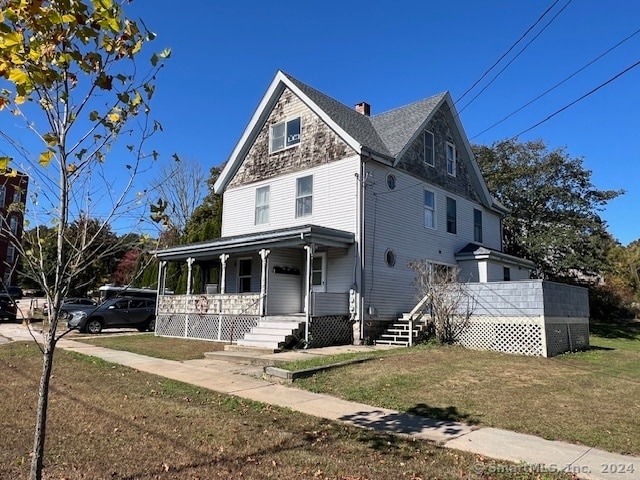 view of front facade with a front lawn and covered porch