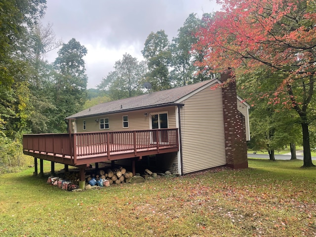 rear view of house with a deck and a yard