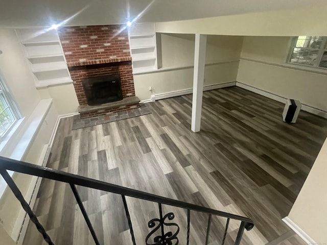 unfurnished living room with hardwood / wood-style flooring and a brick fireplace