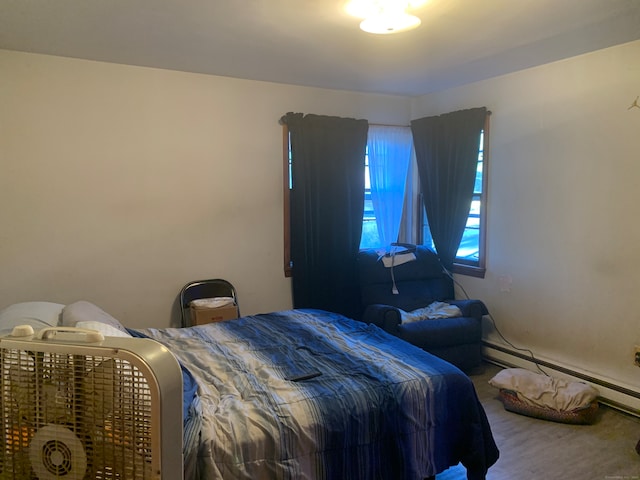 carpeted bedroom featuring a baseboard heating unit