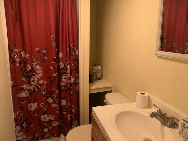 bathroom with vanity, walk in shower, and toilet