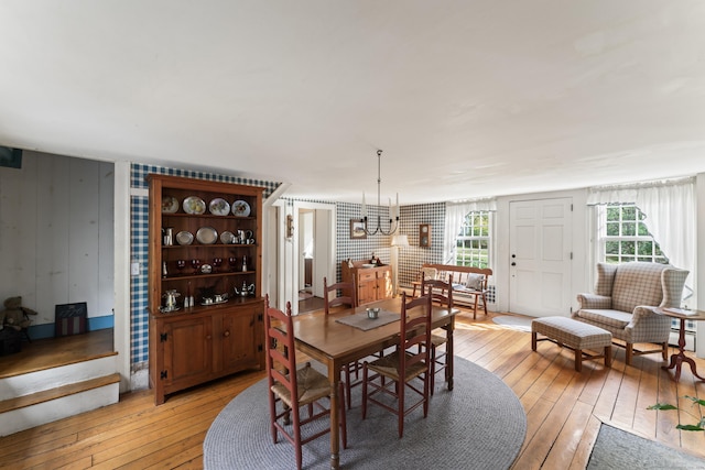 dining space featuring baseboard heating, light wood finished floors, and a chandelier