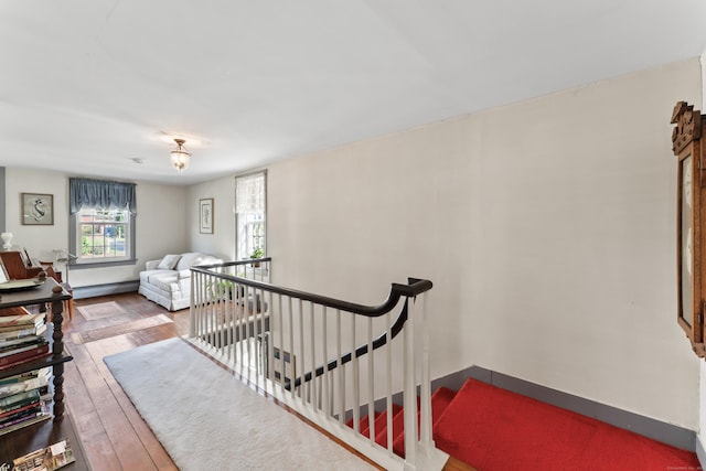 stairs featuring baseboards, a baseboard radiator, and hardwood / wood-style floors