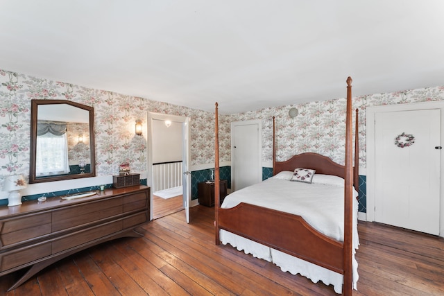 bedroom with hardwood / wood-style flooring and wallpapered walls