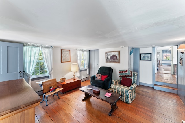 living room featuring hardwood / wood-style flooring, a baseboard heating unit, and a wealth of natural light