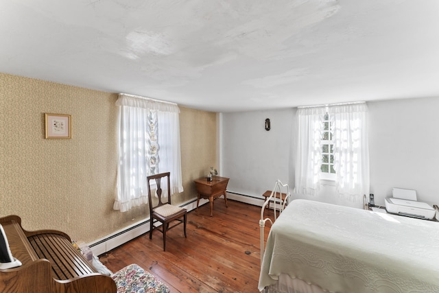 bedroom featuring baseboard heating, hardwood / wood-style floors, and wallpapered walls