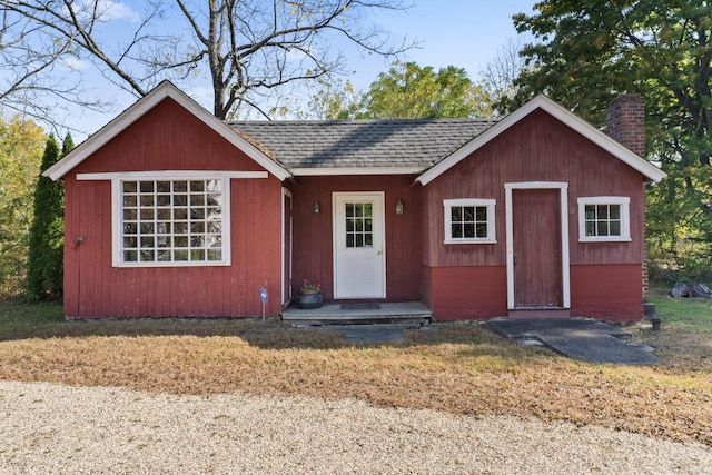 ranch-style home with a chimney and a shingled roof