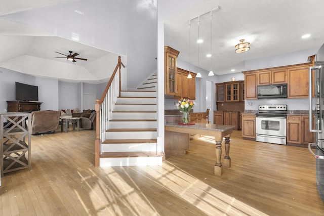 kitchen with pendant lighting, a kitchen breakfast bar, ceiling fan, light hardwood / wood-style floors, and electric stove