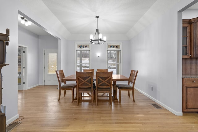 dining space with plenty of natural light, a chandelier, and light wood-type flooring