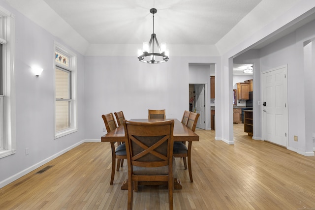 dining space with a notable chandelier and light hardwood / wood-style floors